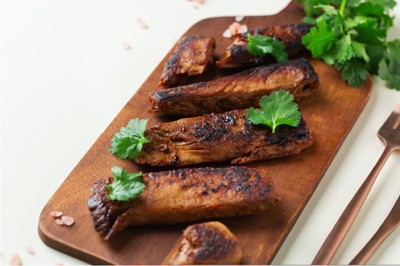 A plate of vegan ribs with jackfruit, garnished with parsley.